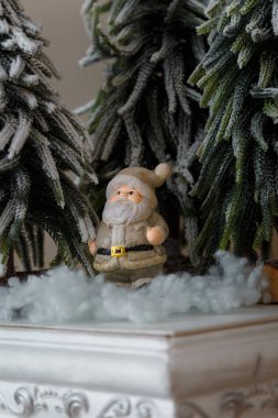 Karlı, yapay köknar ağaçlarının altında pofuduk karda Noel Baba oyuncağı. Mutlu Noeller, Mutlu Yeni Yıl dekoratif unsurları. Sihirli Noel sembolü