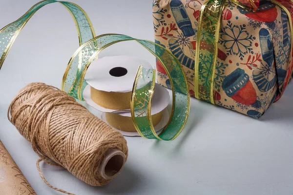 Diy包装的圣诞快乐礼品盒的过程中 牛皮纸 绿带线轴 轻质背景黄麻绳 — 图库照片
