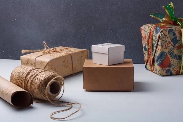 Quelques Cadeaux Noël Enveloppés Rouleau Papier Bobine Corde Sur Table — Photo