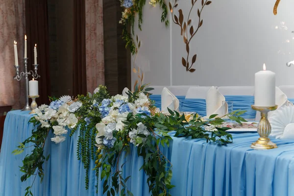 装饰蓝婚纱主席团 喜庆餐桌和拱门为新婚 活动的组织 美丽的花朵和燃烧的蜡烛 — 图库照片
