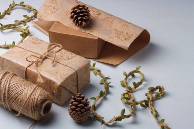 Noel hediyesi ambalajı, çevre dostu dekor, çam kozalakları, jüt ip ve ambalaj kağıdı. Doğal, ekolojik olarak temiz malzemeler.