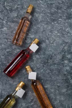 Gri arka planda boş etiketli 250 ml şişe. Kırmızı, pembe ve beyaz şarap çeşitleri. Dikey çekim, boşluğu kopyala