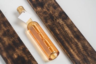 Tahta arka planda 250 ml beyaz şarap şişesi. Chardonnay, riesling, sauvignon blanc çeşit şarap. Alkol iç.