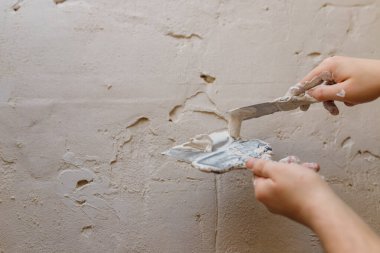 Duvarda macun kullanan spatula kullanan erkek eller, tadilat yapan inşaatçılar..