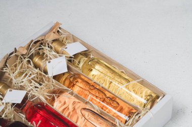 Tahta talaş kutusunda 250 ml kırmızı, pembe, beyaz şarap var. Etiketi yok. Hediye ya da kutlama için içki seti