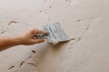 Duvarda macun kullanan spatula kullanan erkek eller, tadilat yapan inşaatçılar..