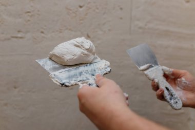 Duvarda macun kullanan spatula kullanan erkek eller, tadilat yapan inşaatçılar..