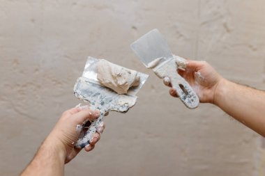 Duvarda macun kullanan spatula kullanan erkek eller, tadilat yapan inşaatçılar..