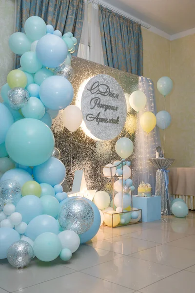 Arch of blue balloons for boy party. Number 1 for one year old baby. Decorative elements, star, photo zone. Inscription Happy Birthday Artem. Vertical shot