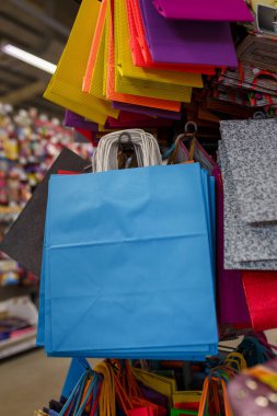 İzmail, Ukrayna. Şubat 2022. Süpermarkette ya da alışveriş merkezinde doğum günü hediyeleri için mavi ve diğer parlak renkli kağıt poşetler..