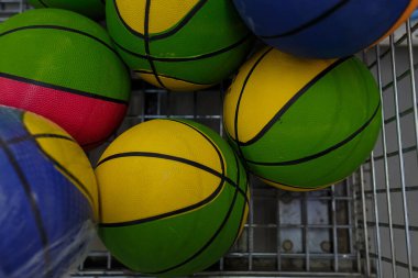Alışveriş arabasında birkaç parlak basketbol topu süpermarkette ya da spor mağazasında renkli spor aletleri. Üst görünüm