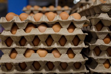 Markette ya da süpermarkette tekrar kullanılabilir kağıt kaplarda kahverengi tavuk yumurtası. Paskalya indirimi, sıfır atık, ekolojik ambalaj.