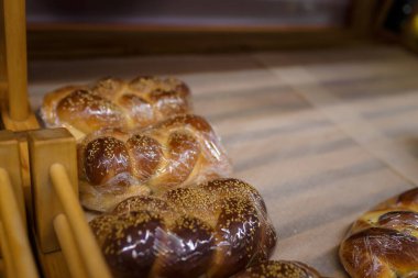 Plastik paketlerde susamlı çörekler süpermarketteki ahşap raflarda, bakkalda, yerel pastanede.