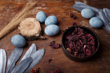 Kuru Hibiscus çayı ve ahşap arka planda gümüş dekoratif tüylü güzel mavi paskalya yumurtaları.