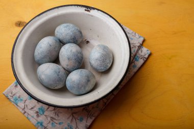 Beyaz kasede parlak sarı arka planda mavi Paskalya yumurtaları. Ukrayna 'da Paskalya 2022. Ukrayna ulusal bayrak renkleri. Boşluğu kopyala.