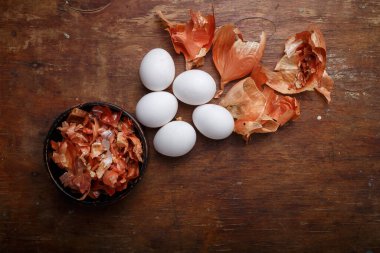 Evde onin kabuğu kullanarak resim yapan Paskalya yumurtaları. Doğal bitkinin kahverengi eko boyası. Üst görünüm, alanı kopyala.