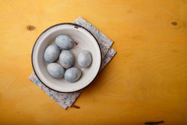 Beyaz kasede parlak sarı arka planda mavi Paskalya yumurtaları. Ukrayna 'da Paskalya 2022. Ukrayna ulusal bayrak renkleri. Boşluğu kopyala, üst görünüm