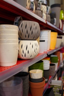 Süpermarketin rafındaki farklı plastik saksılar. Dükkandaki ya da tarımsal dükkandaki saksılar.