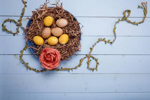Schön Bemalte Ostereier Dekorativem Nest Mit Stoffrosenblume Auf Blauem Holzgrund — Stockfoto