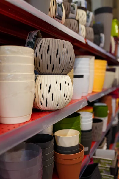 Süpermarketin rafındaki farklı plastik saksılar. Dükkandaki ya da tarımsal dükkandaki saksılar.