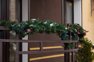Noel için yeşil süslemeli korkuluklar, mavi boncuklar ve köknar konileri, Yeni Yıl kutlamaları