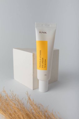 İzmail, Ukrayna. Mart 2022. IUNIK Propolis göz ve yüz için vitamin kremi. Beyaz arka planda sazlıklar ile kozmetik tüpü