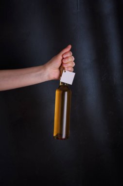 Üzerinde şablon etiketi olan beyaz şarap şişesi, markasız. Riesling, chardonnay, sauvignon blanc. Siyah arkaplanda alkol içeceği