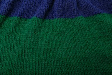 Örgü çizgili yeşil kumaş dokusu, arka plan. Tekstil, sweatshirt ya da süveter desenli yüzey. Sıcak aksesuarlar, kıyafetler, moda.