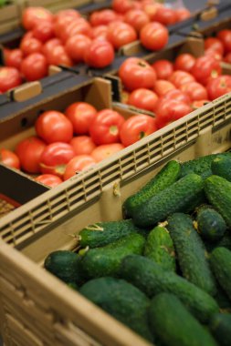 Domatesli ve salatalıklı kutular. Marketteki, süpermarketteki, alışveriş merkezindeki, hipermarketteki ya da alışveriş merkezindeki sebze reyonunun yumuşak odaklı görüntüsü. Vejetaryen sağlıklı gıda konsepti.