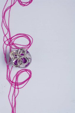 Dikey çekim, Mutlu Noeller kartı, gümüş renkli köknar ağacı oyuncağı ve parlak arkaplanda pembe boncuklar. Metin için yer, kopyalama alanı.