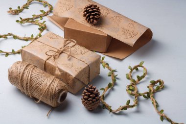 Noel hediyesi ambalajı, çevre dostu dekor, çam kozalakları, jüt ip ve ambalaj kağıdı. Doğal, ekolojik olarak temiz malzemeler.