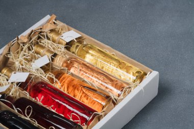 Tahta talaş kutusunda 250 ml kırmızı, pembe, beyaz şarap var. Etiketi yok. Hediye ya da kutlama için içki seti