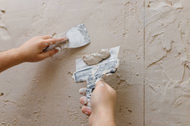 Duvarda macun kullanan spatula kullanan erkek eller, tadilat yapan inşaatçılar..