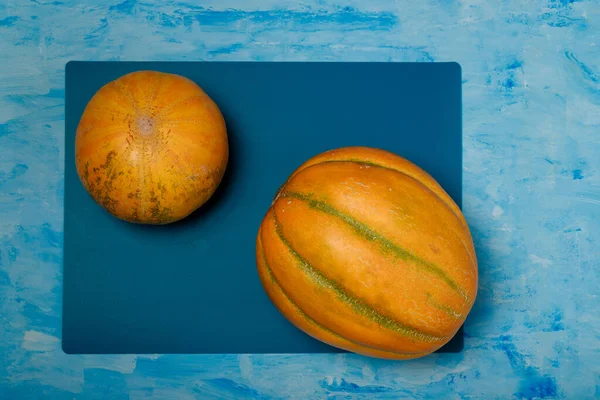 Dos Melones Amarillos Maduros Sobre Fondo Pintado Azul Concepto Frutas — Foto de Stock