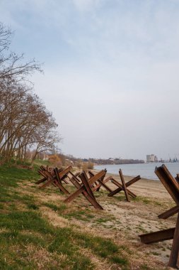 Nehir kıyısında askeri tanksavar kirpileri. Metalik barikat ya da savunma için engel. Ukrayna 2022 'de savaş. Rus saldırganlığı