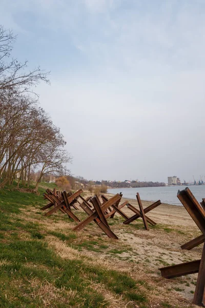 Nehir kıyısında askeri tanksavar kirpileri. Metalik barikat ya da savunma için engel. Ukrayna 2022 'de savaş. Rus saldırganlığı