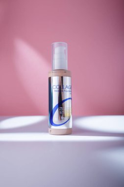İzmail, Ukrayna. Mayıs 2022. SPF 15 ile yeterince Kolajen Nemlendirme Vakfı. Pembe arka planda kozmetik şişesi