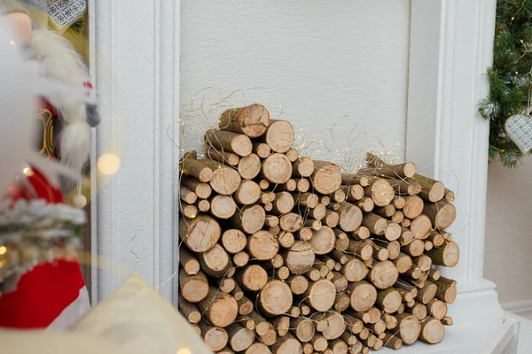 黄金のガーランドで飾られた人工クリスマス暖炉の木製のログ クローズアップ撮影 — ストック写真
