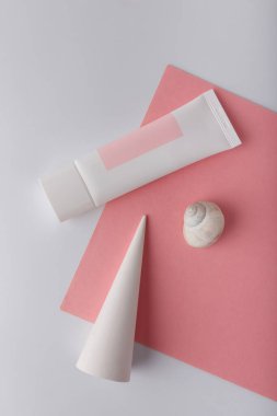 Beyaz kozmetik krem tüpü pembe arka plan şablonunda, model al, marka yok. Yüz bakımı karşıtı cilt bakımı. Beton dekor. Boşluğu kopyala.
