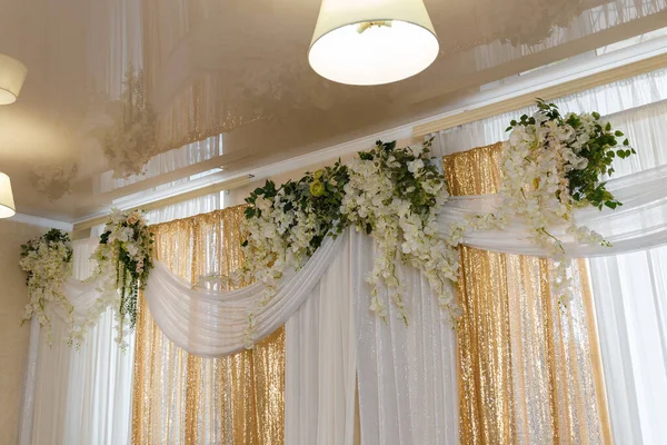 窗户装饰着金光闪闪的白色窗帘 白色人造攀爬花和绿叶 玻璃天花板的反射 — 图库照片