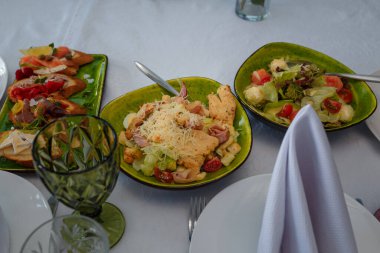 Aperatifli şölen masası. Lahanadan Sezar salatası, tavuk fileto, domates, yumurta ve rendelenmiş peynir. Sebze salatası. Kanepeli tabak..