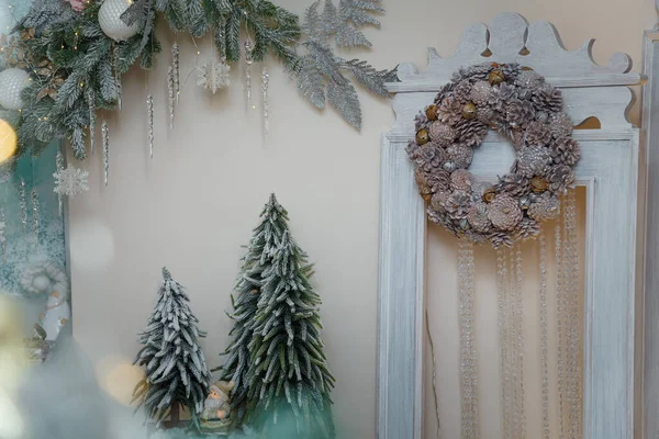 美しい雪の人工モミの木 サンタクロースのおもちゃと松のコーンの花輪が壁にかかっています 集中していない枝を予約します メリークリスマスの装飾 — ストック写真