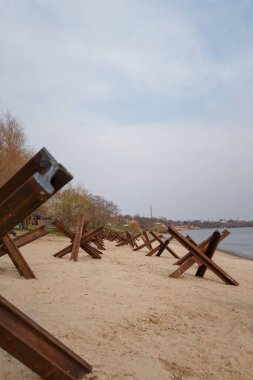 Nehir kıyısında askeri tanksavar kirpileri. Metalik barikat ya da savunma için engel. Ukrayna 2022 'de savaş. Rus saldırganlığı