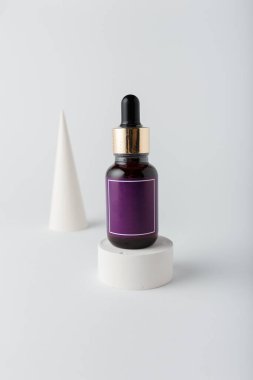 Yüz bakımı kozmetik ürünleri. Beyaz arka planda bir şişe azelaik, salisilik ya da hyaluron asidi, dekoratif beton elementler. Model oluştur, boşluğu kopyala, dikey