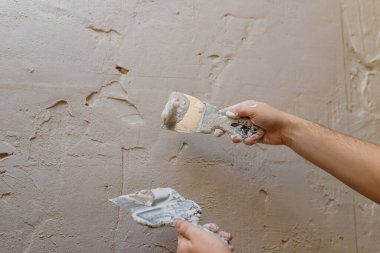 Duvarda macun kullanan spatula kullanan erkek eller, tadilat yapan inşaatçılar..