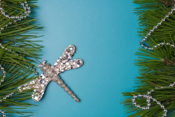 メリークリスマス ハッピーニューイヤーお祝いのポストカード テンプレート 青の背景 松の木の枝フレーム シルバービーズ 光沢のあるトンボのおもちゃ スペースのコピー — ストック写真