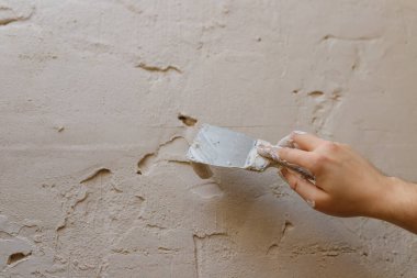 Duvarda macun kullanan spatula kullanan erkek eller, tadilat yapan inşaatçılar..