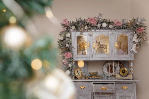 人工的な雪のモミの枝 氷のバラ ロッキング馬のおもちゃ 黄金のクリスマスのガーランドライトで飾られた美しいシェルビーシックな食器棚がブック — ストック写真