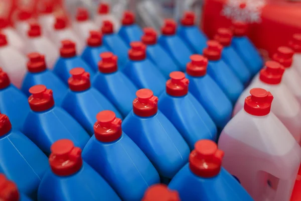 Blue and white bottles with household chemicals in supermarket, store, shop. Dishwashing liquid, dish soap assortment