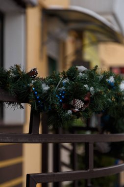 Noel için yeşil süslemeli korkuluklar, mavi boncuklar ve köknar konileri, Yeni Yıl kutlamaları